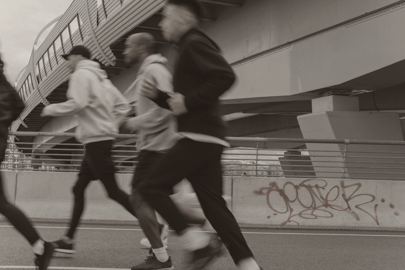 Grupo de corredores en movimiento bajo un paso elevado